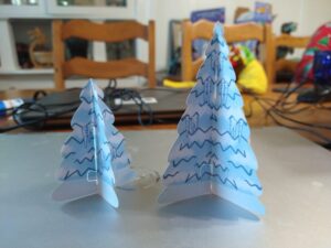 Two papercraft snow-covered pine trees