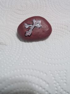 Red river rock with white bones painted on 