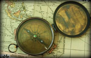 An image of an open compass against an old map as a backdrop.